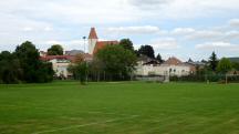 Blick ber den Sportplatz zur Kath. Pfarrkirche hl. Petronilla 