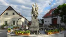 Blick zur Brunnenfigur des heiligen Florian mit 2 reliefierten Wappen
