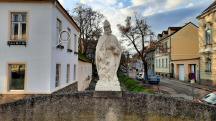 Blick zur Urban-Statue auf der Brstung der Brcke ber den Loisbach