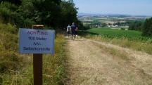  Blick auf die Wanderstrecke mit einer Infotafel 